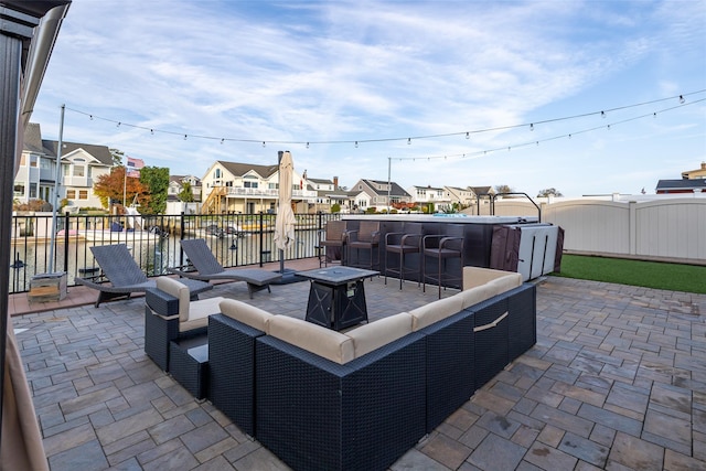 view of patio / terrace with a water view, an outdoor bar, and an outdoor living space with a fire pit