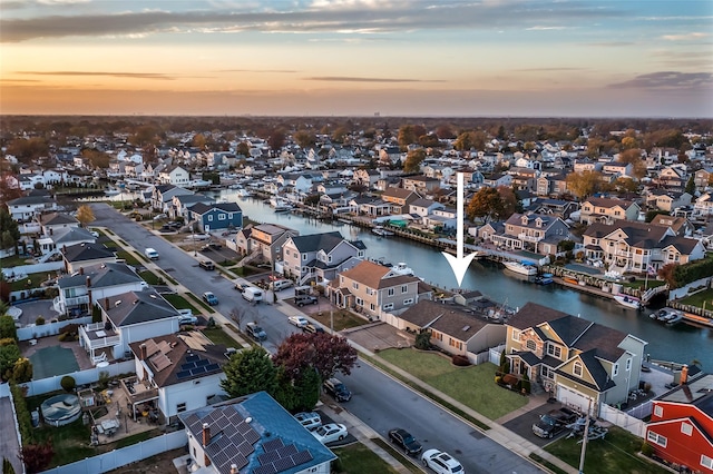 aerial view at dusk featuring a water view