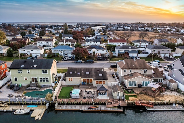 aerial view at dusk featuring a water view