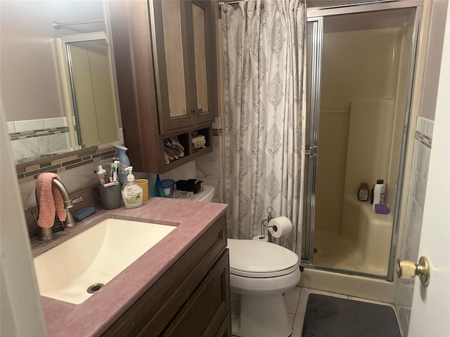 bathroom featuring toilet, a shower with shower door, vanity, tile patterned flooring, and backsplash