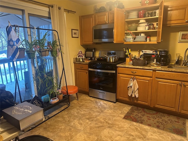 kitchen with stainless steel appliances, sink, and dark stone counters