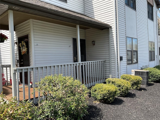 doorway to property with a porch and central AC