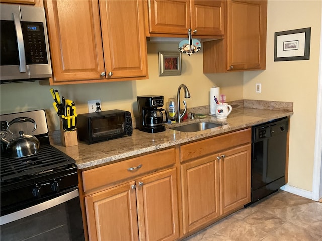 kitchen with light stone countertops, a sink, stainless steel appliances, brown cabinetry, and a toaster