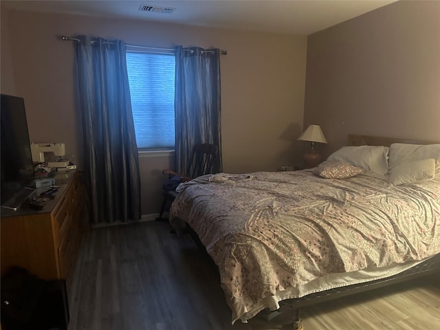 bedroom featuring dark wood-style floors and visible vents