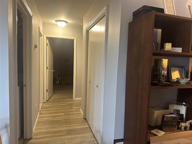 corridor featuring baseboards and light wood-style floors