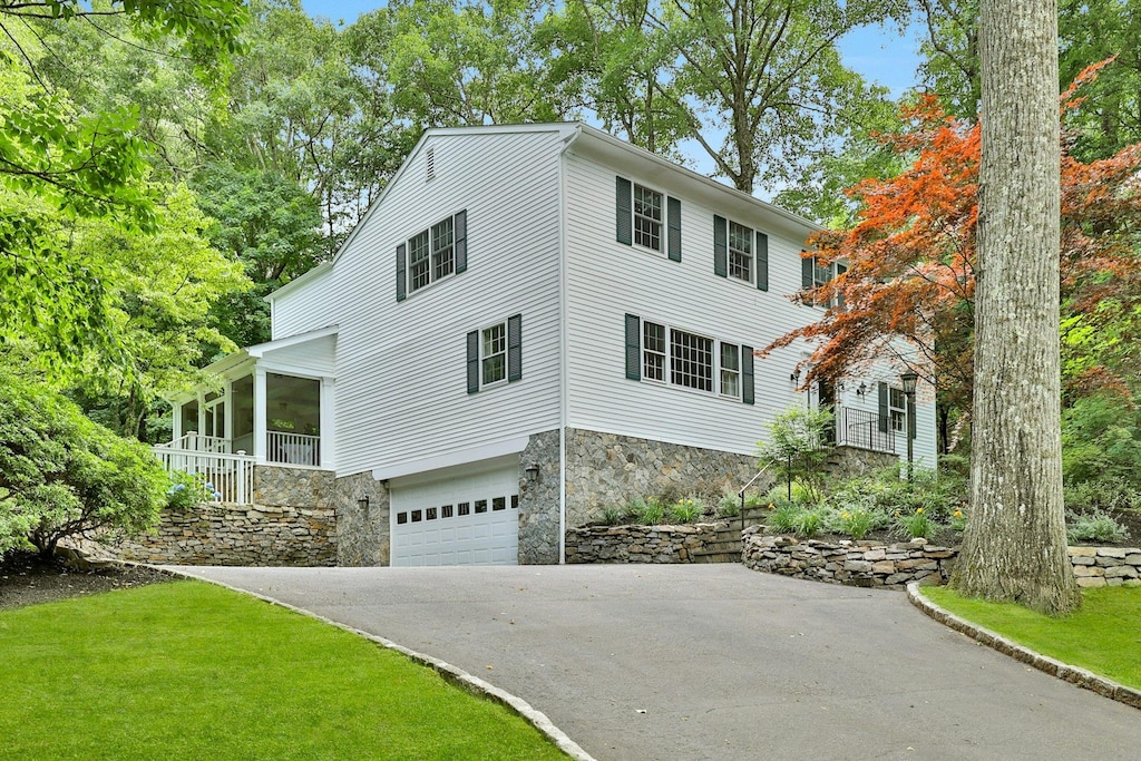 18 Valley Ln, Chappaqua, NY 10514 - view of front of property featuring a garage, a front yard, and a sunroom