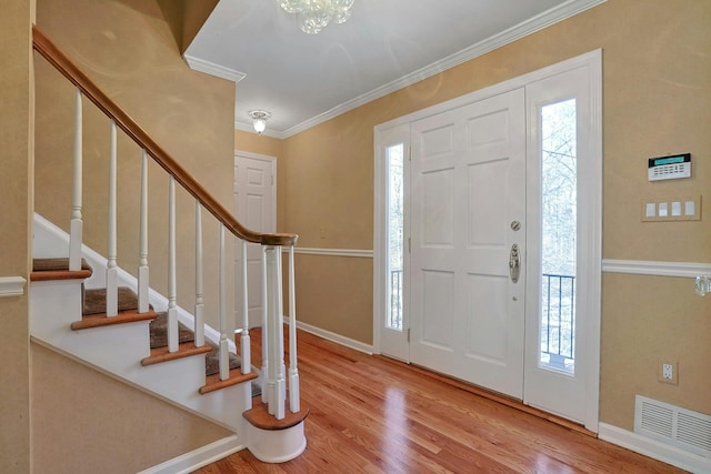 entryway featuring wood-type flooring and crown molding