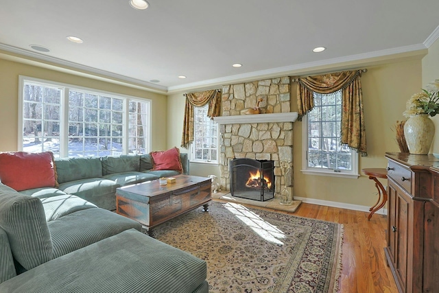 living room featuring crown molding, a fireplace, hardwood / wood-style flooring, and a wealth of natural light