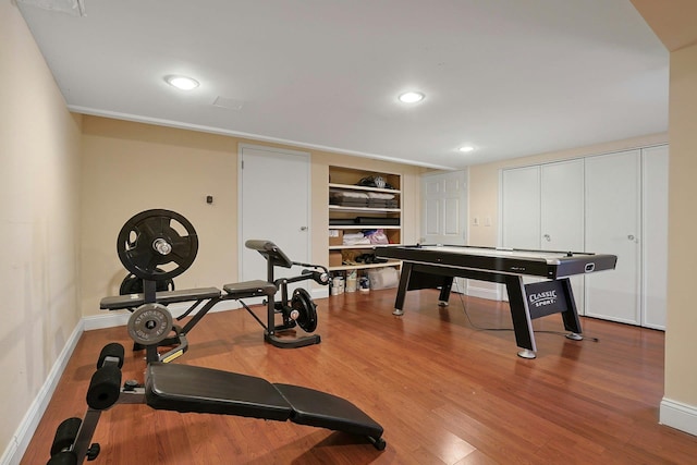 exercise area with hardwood / wood-style flooring and built in features