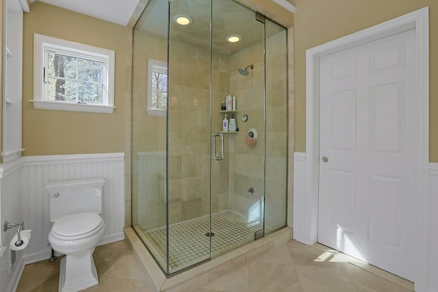 bathroom featuring tile patterned flooring, walk in shower, and toilet