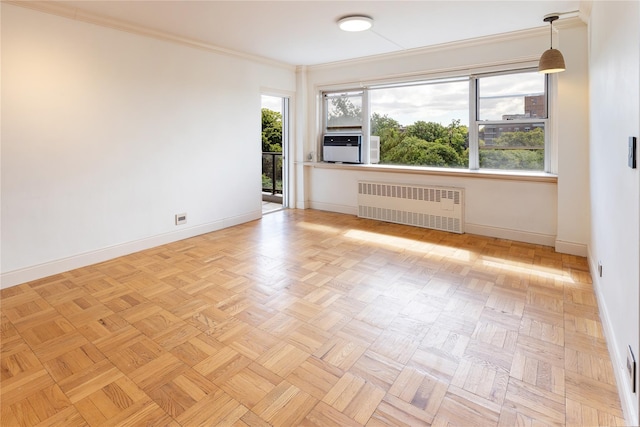 unfurnished room with cooling unit, radiator heating unit, crown molding, and light parquet floors