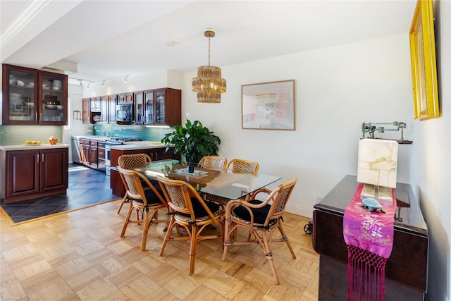 dining space featuring a notable chandelier and light parquet floors