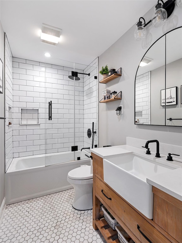 full bathroom with bath / shower combo with glass door, toilet, tile patterned flooring, and vanity