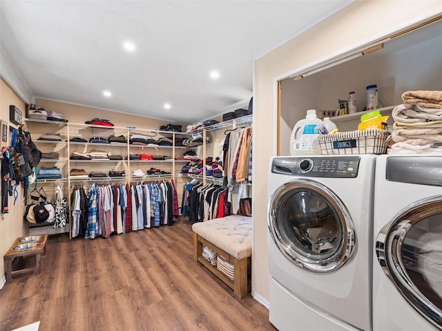 clothes washing area with hardwood / wood-style flooring, crown molding, and independent washer and dryer