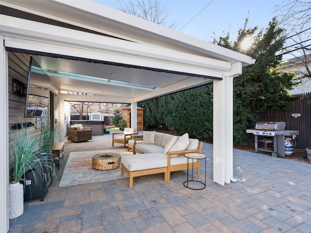 view of patio with a shed, a hot tub, area for grilling, and an outdoor living space with a fire pit