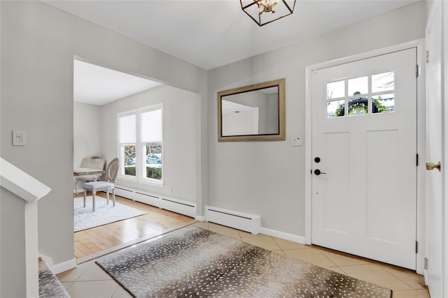 foyer entrance featuring light tile patterned floors, a wealth of natural light, and baseboard heating