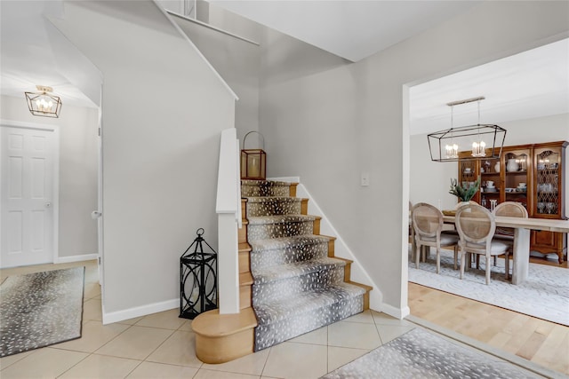 stairs featuring a chandelier and tile patterned flooring