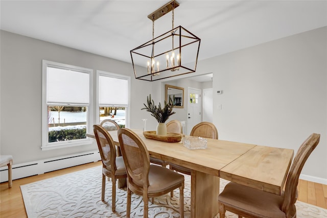 dining room featuring a baseboard heating unit and light hardwood / wood-style floors