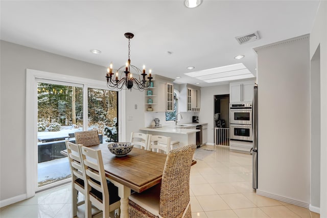 dining area with a chandelier, sink, and light tile patterned floors