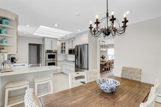 dining area with sink, a chandelier, and baseboard heating