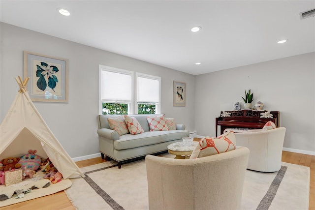 living room featuring a baseboard heating unit and light hardwood / wood-style flooring