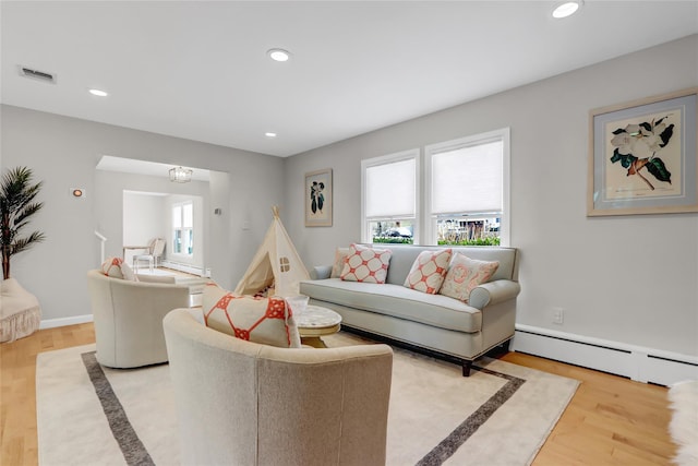 living room with light hardwood / wood-style flooring and a baseboard heating unit