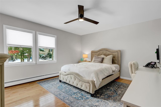 bedroom featuring baseboard heating, ceiling fan, and light hardwood / wood-style flooring