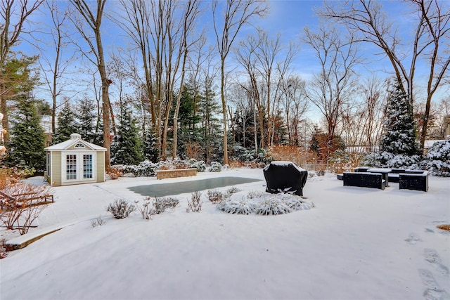 yard layered in snow featuring an outbuilding