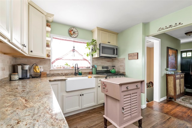 kitchen with sink, backsplash, appliances with stainless steel finishes, and a center island