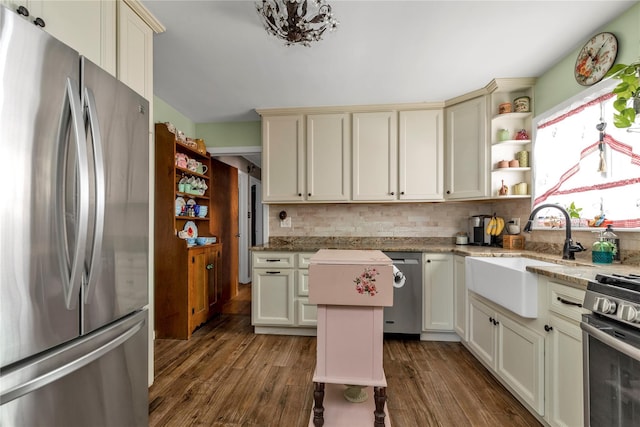 kitchen featuring appliances with stainless steel finishes, sink, cream cabinetry, tasteful backsplash, and dark hardwood / wood-style floors