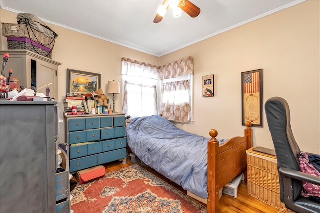 bedroom with crown molding, hardwood / wood-style floors, and ceiling fan