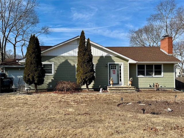 single story home with roof with shingles, a chimney, and an attached garage