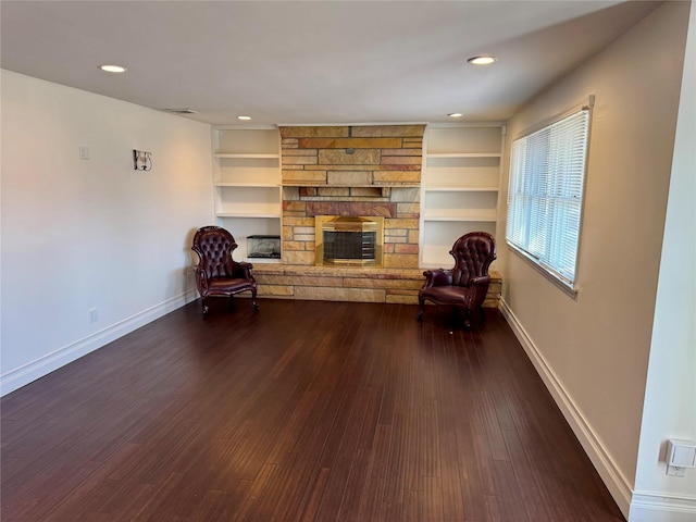 unfurnished room with recessed lighting, dark wood-style flooring, a fireplace, and baseboards