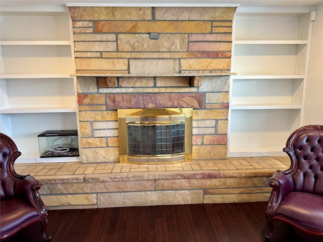 living area featuring wood finished floors and a stone fireplace