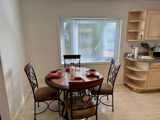 dining room with light wood-type flooring and baseboards