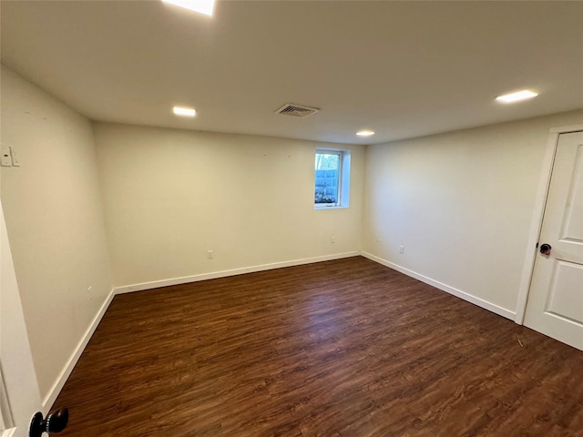 below grade area with dark wood-style flooring, recessed lighting, visible vents, and baseboards