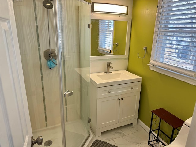 full bathroom featuring a wealth of natural light, marble finish floor, a shower stall, and vanity