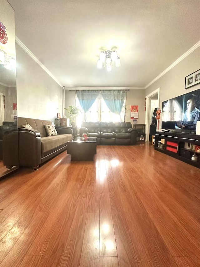 unfurnished living room with hardwood / wood-style floors and crown molding