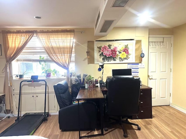 home office with light hardwood / wood-style flooring