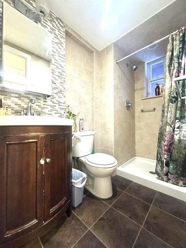 bathroom with backsplash, a shower with shower curtain, vanity, tile patterned floors, and toilet