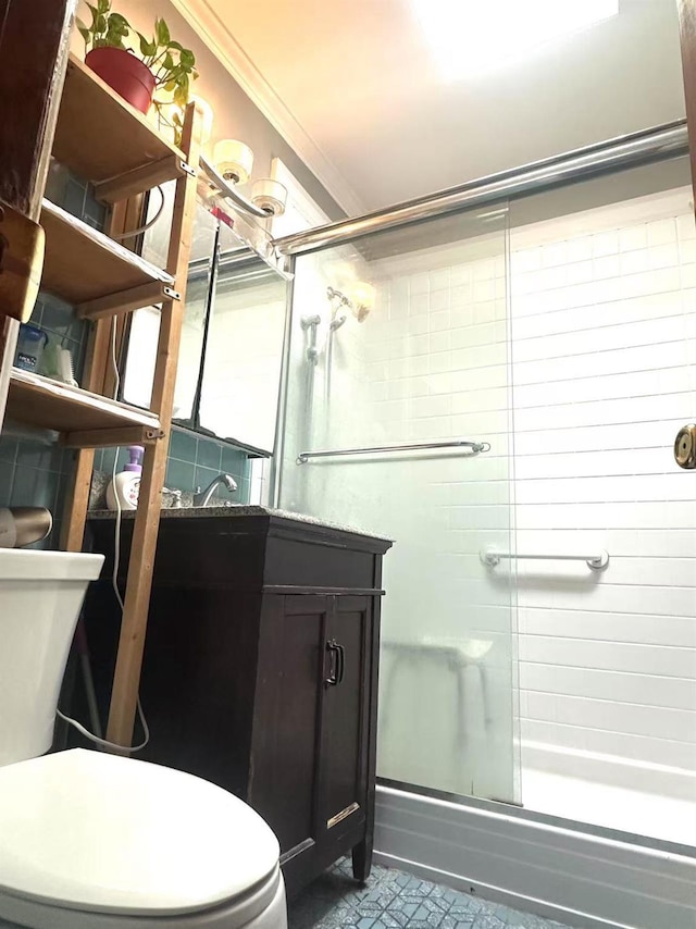 bathroom featuring crown molding, toilet, and bath / shower combo with glass door