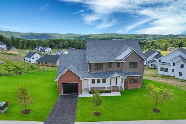 view of front of property featuring a porch, a garage, and a front yard