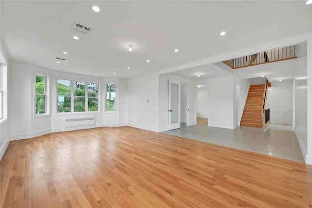 unfurnished living room featuring light wood-type flooring and radiator