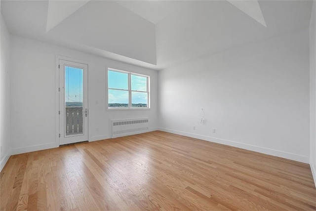 empty room with radiator heating unit and light hardwood / wood-style flooring