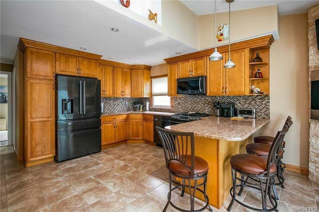 kitchen featuring decorative light fixtures, a kitchen breakfast bar, backsplash, kitchen peninsula, and black fridge with ice dispenser