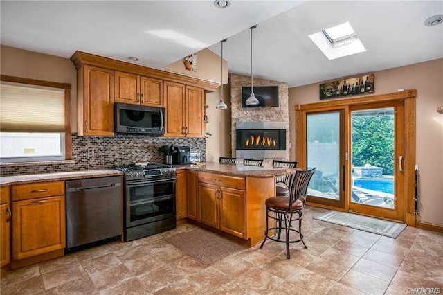 kitchen with dishwasher, a kitchen breakfast bar, decorative light fixtures, kitchen peninsula, and range with two ovens