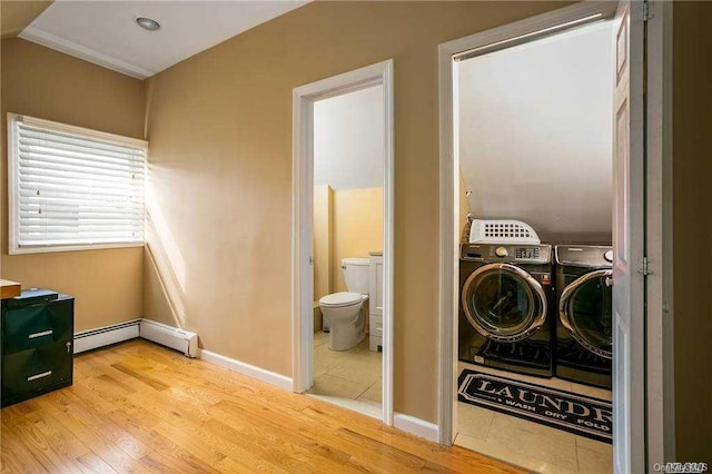 laundry room featuring light hardwood / wood-style flooring, separate washer and dryer, and a baseboard heating unit