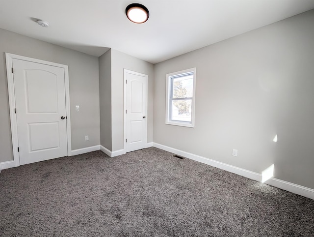 unfurnished bedroom featuring dark colored carpet