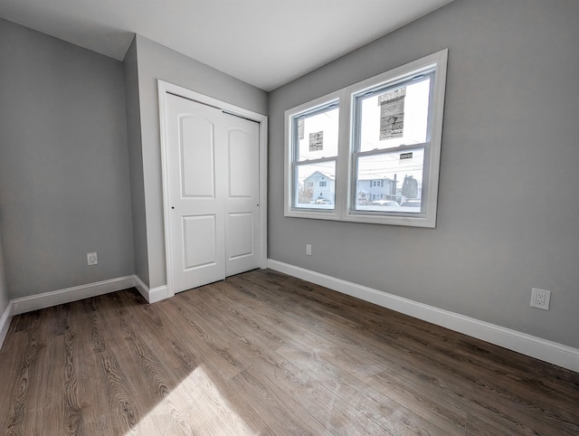 unfurnished bedroom featuring a closet and hardwood / wood-style floors