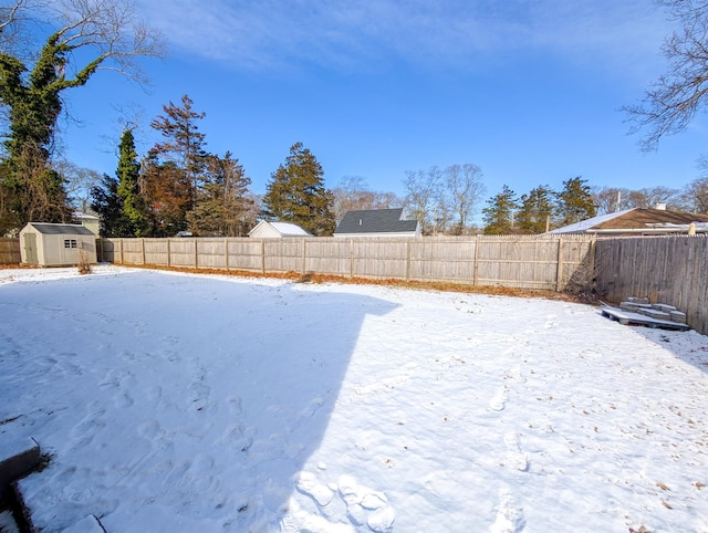 yard layered in snow featuring a shed